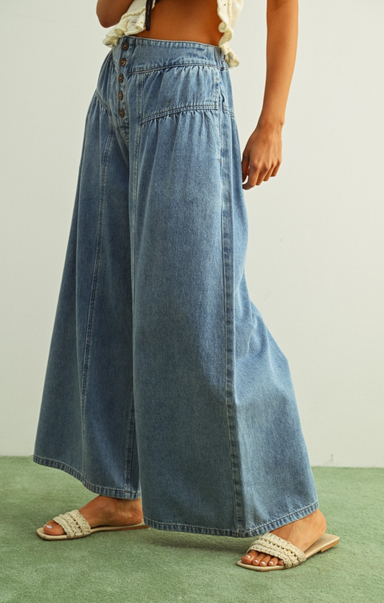 Long denim skirt worn by a person on a neutral background