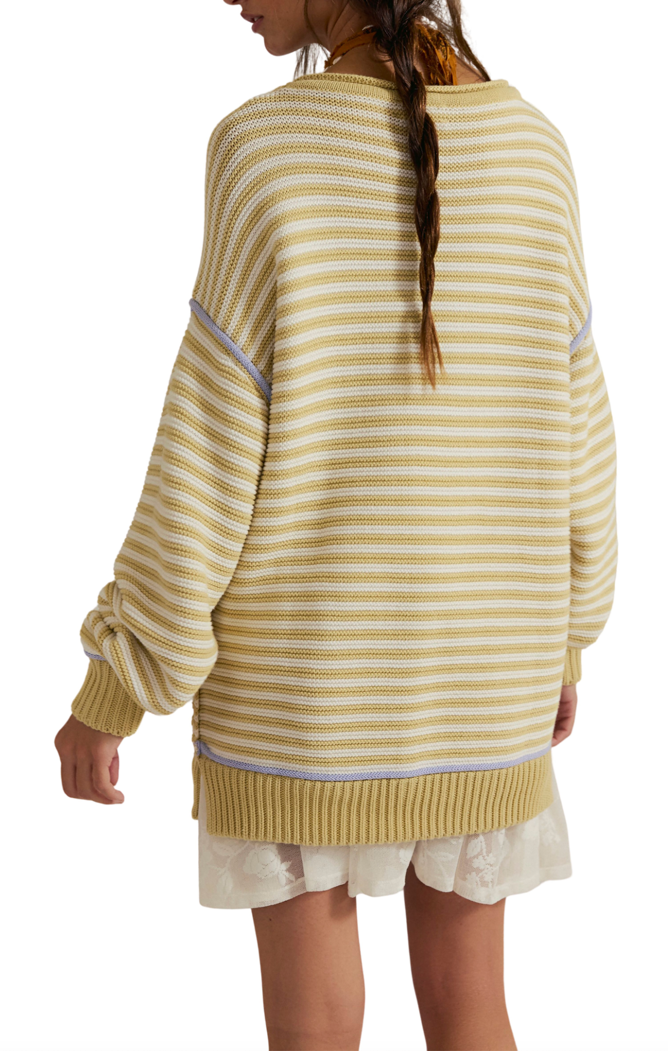 Person wearing a yellow and white striped sweater with a plain background