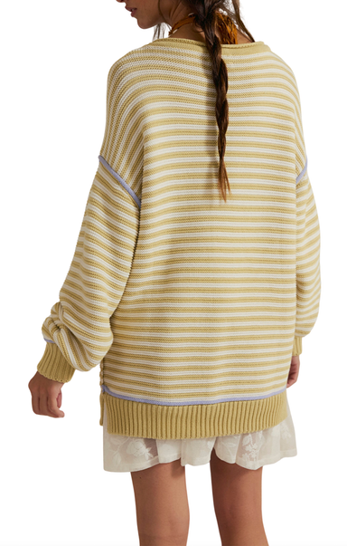 Person wearing a yellow and white striped sweater with a plain background