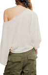 Woman wearing a beige off-shoulder top and green cargo pants on a white background