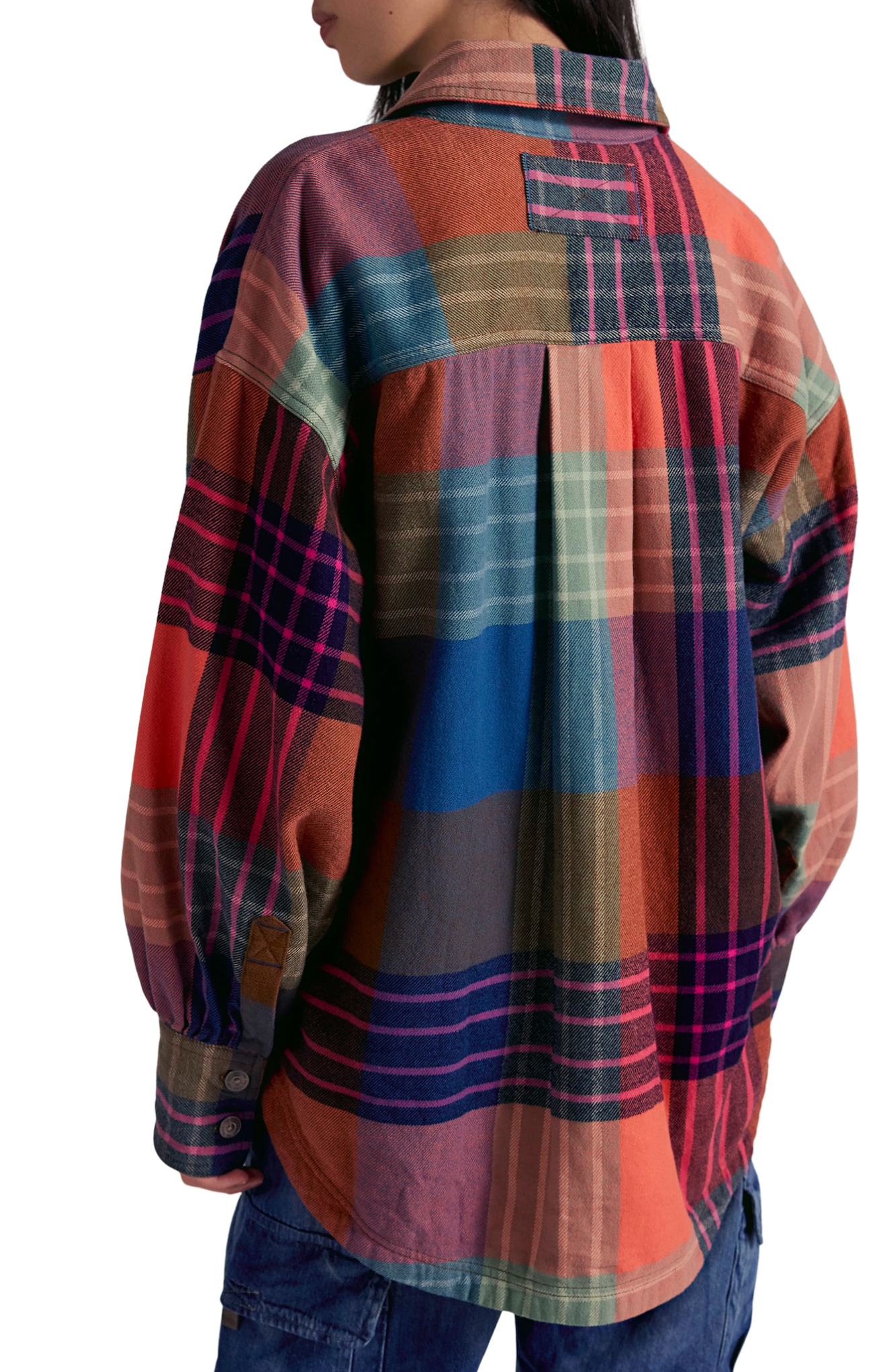 Multicolored plaid shirt worn by a person on a white background