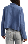 Blue textured jacket worn by a person on a white background