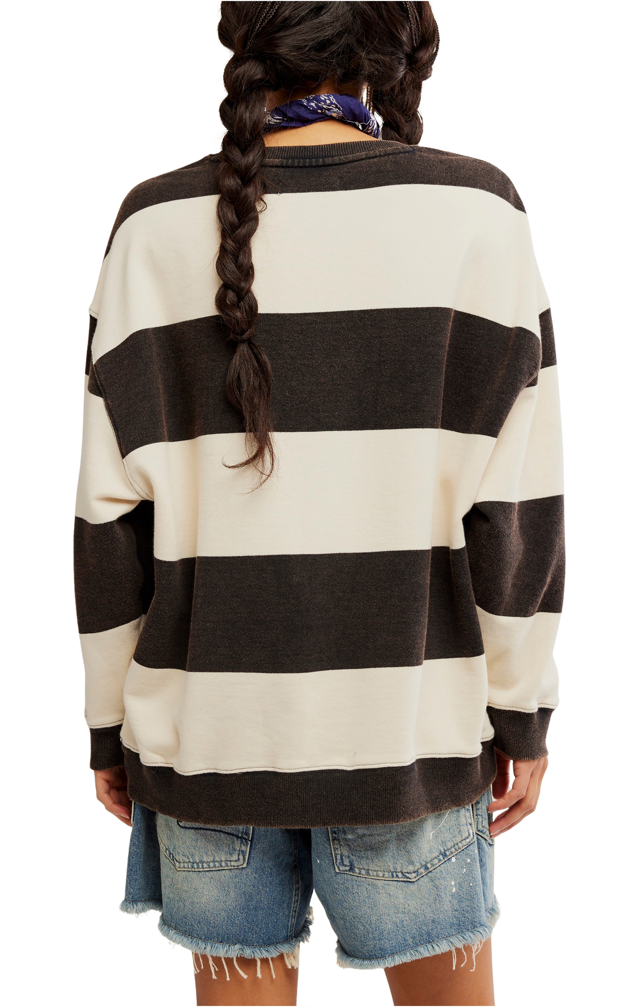 Person wearing a black and white striped sweater with denim shorts on a white background