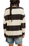 Person wearing a black and white striped sweater with denim shorts on a white background