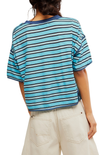 Person wearing a blue and white striped shirt with beige pants on a plain background
