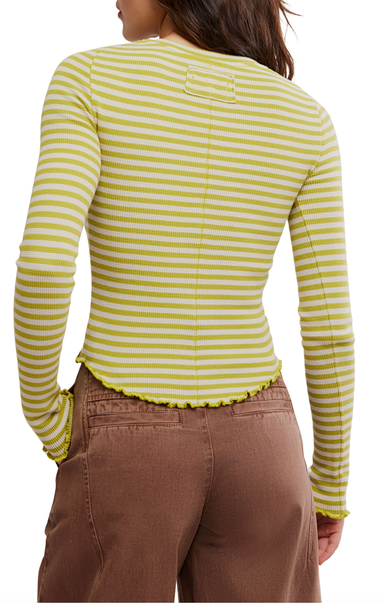 Person wearing a yellow and white striped long-sleeve shirt with brown pants on a white background