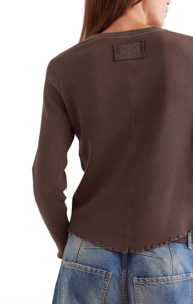 Brown textured sweater worn by a person on a white background