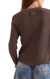 Brown textured sweater worn by a person on a white background
