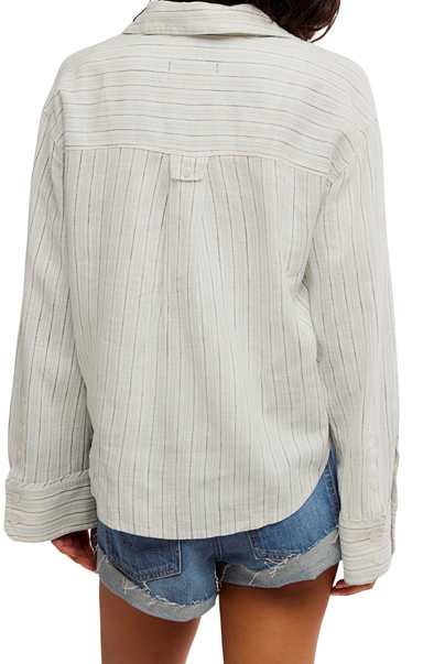 Light-colored ribbed sweater worn by a person on a white background