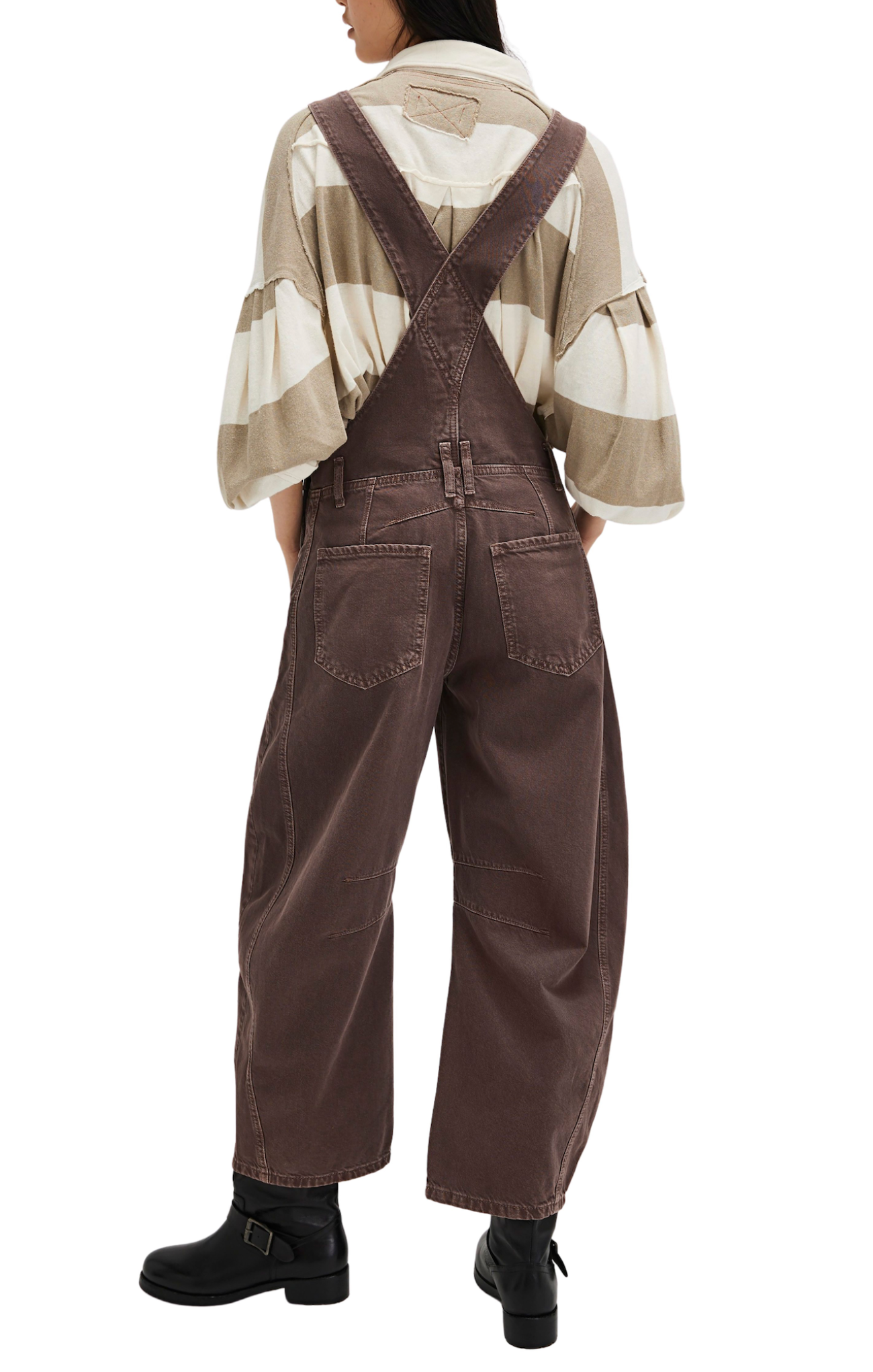 Person wearing brown overalls and a patterned shirt on a white background