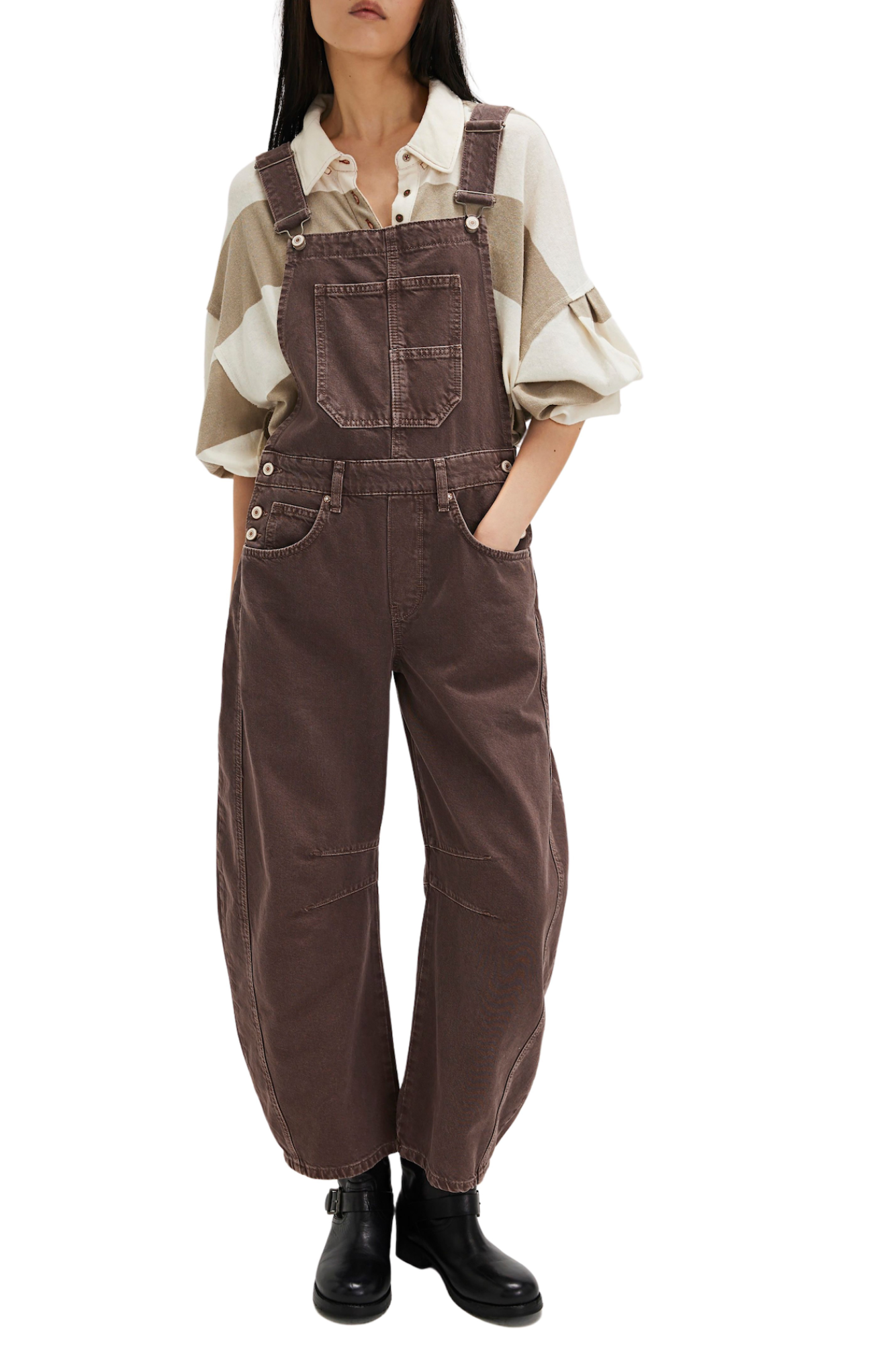 Person wearing brown overalls with a white shirt underneath on a white background