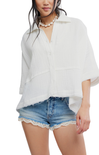 Woman wearing a white blouse and denim shorts on a white background