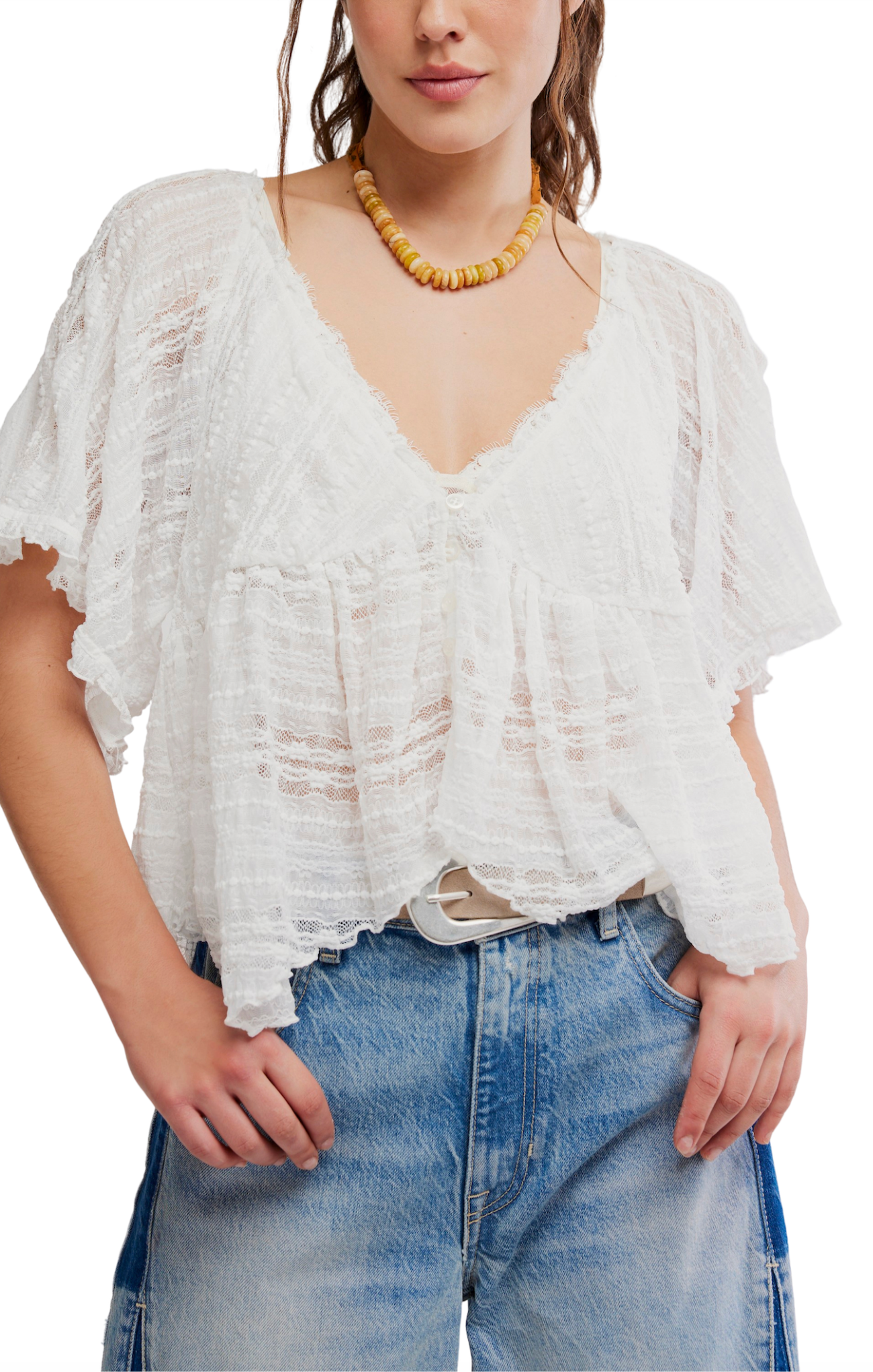Woman wearing a white lace top and blue jeans on a white background