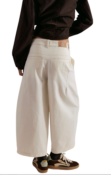 Person wearing beige wide-leg pants with a plain background