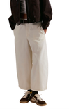 Person wearing beige wide-leg pants on a white background