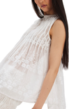 White sleeveless top with lace detailing worn by a model on a white background