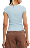 Light blue ribbed cap sleeve top worn by a person on a white background