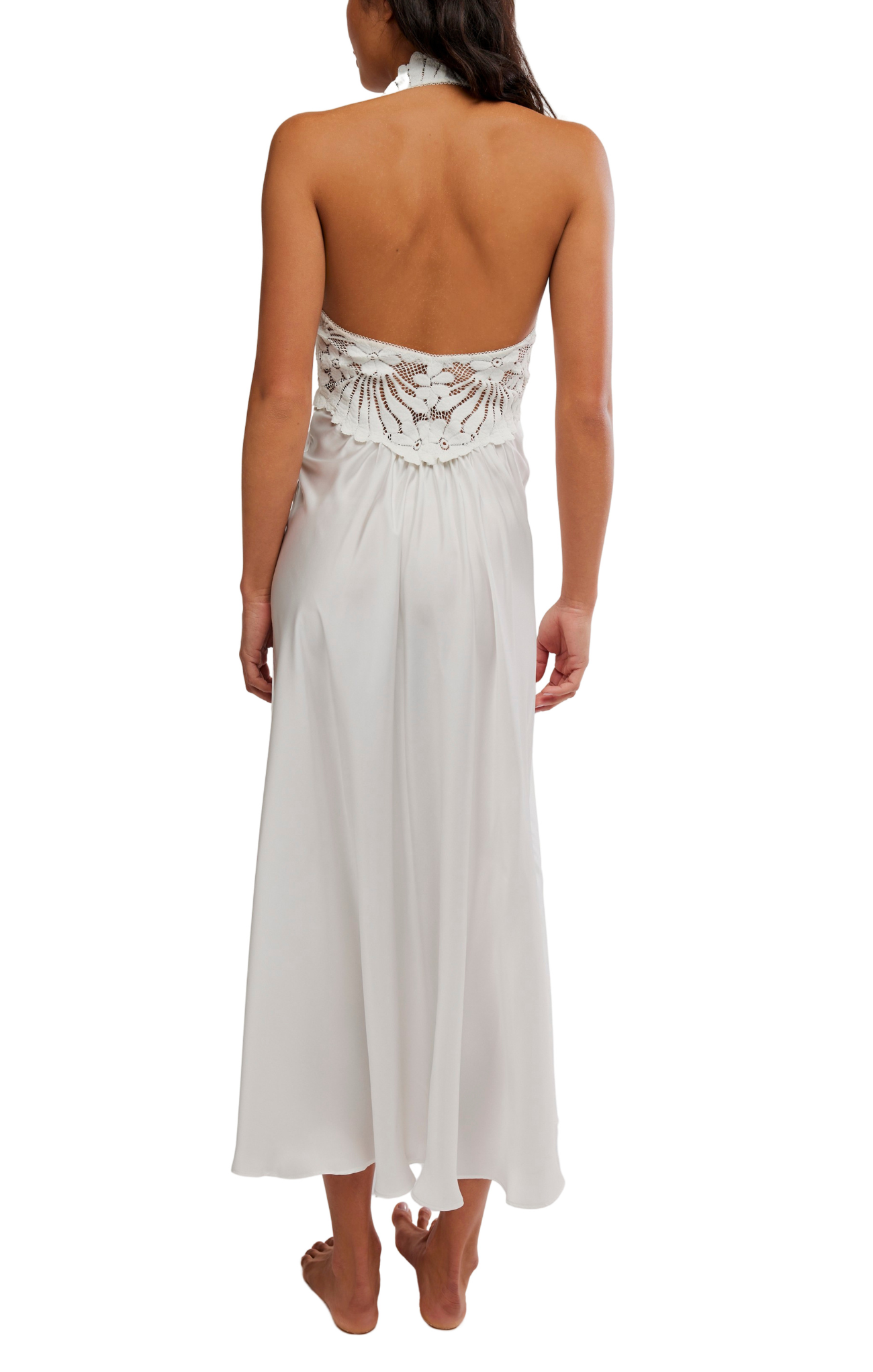 Woman wearing a white strapless dress with lace detailing on a white background