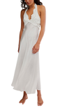 Woman wearing a white halter neck dress on a white background