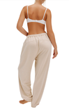 Woman wearing a white bra and beige pants on a white background