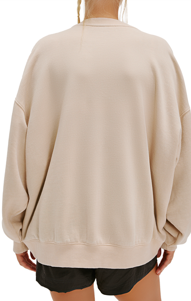 Beige oversized sweatshirt worn by a person on a white background