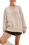 Beige oversized sweatshirt worn by a person on a white background