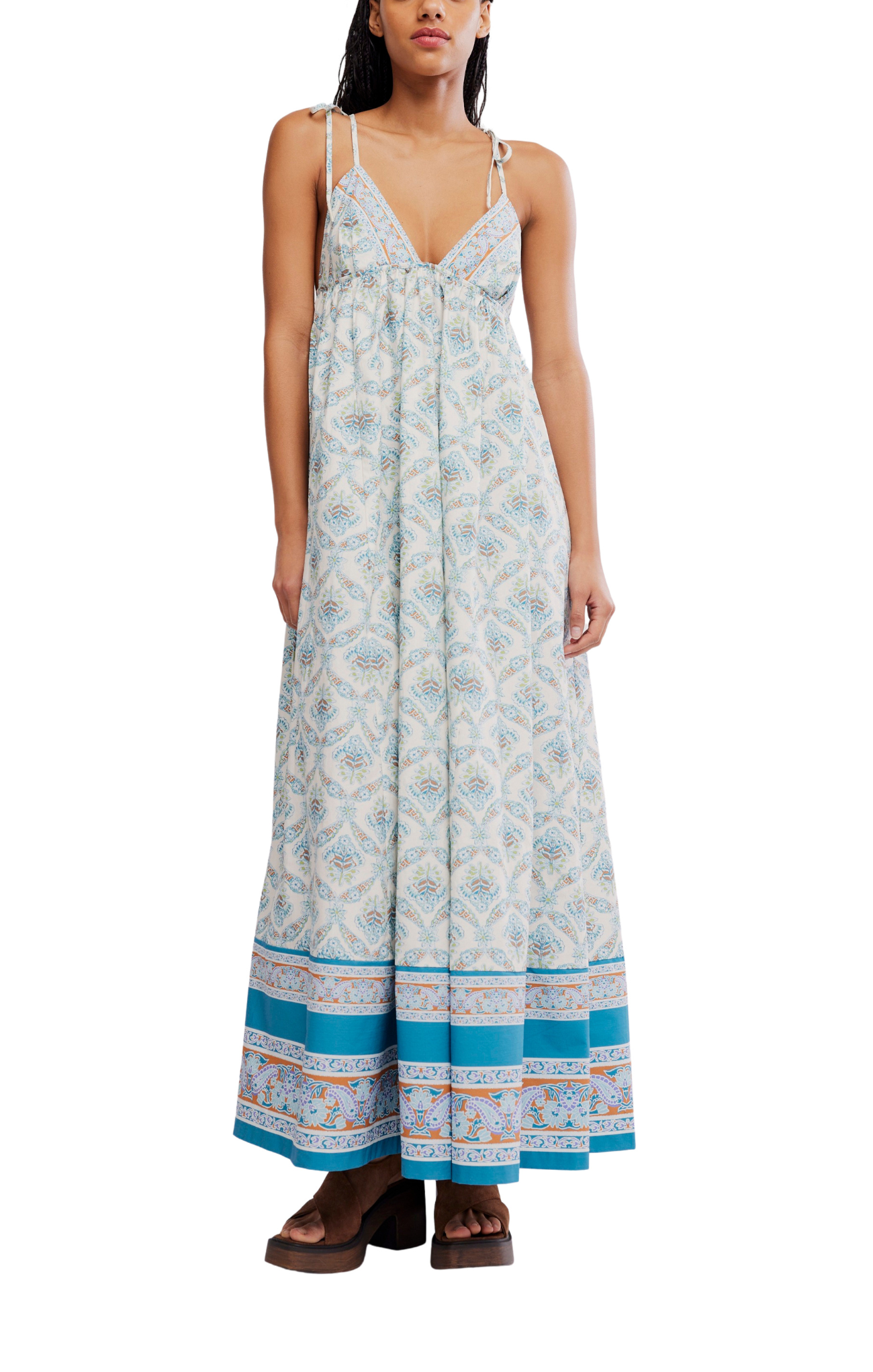Woman wearing a floral patterned dress with blue accents on a white background