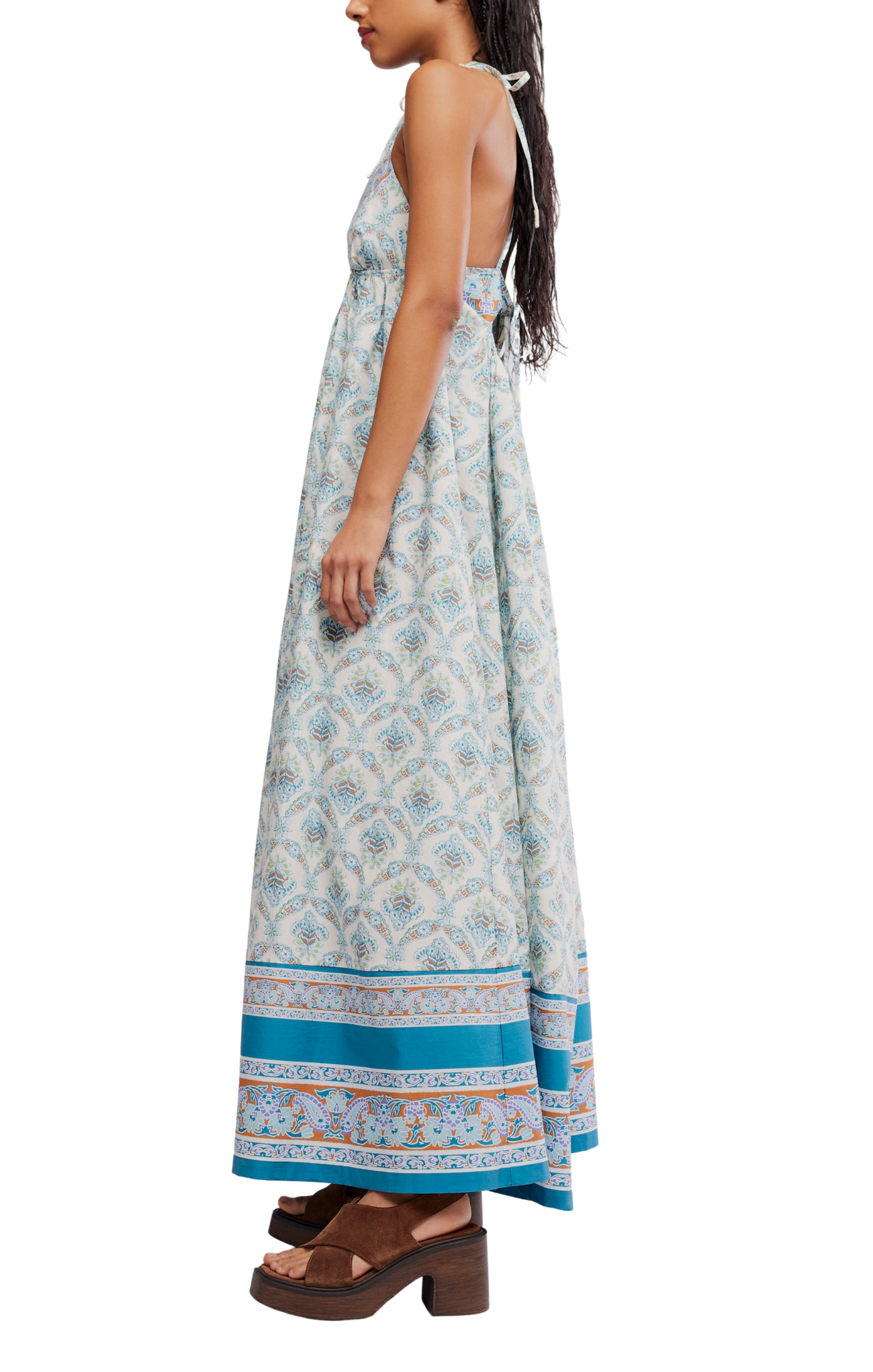 Woman wearing a long floral dress with a blue border on a white background