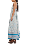 Woman wearing a long floral dress with a blue border on a white background