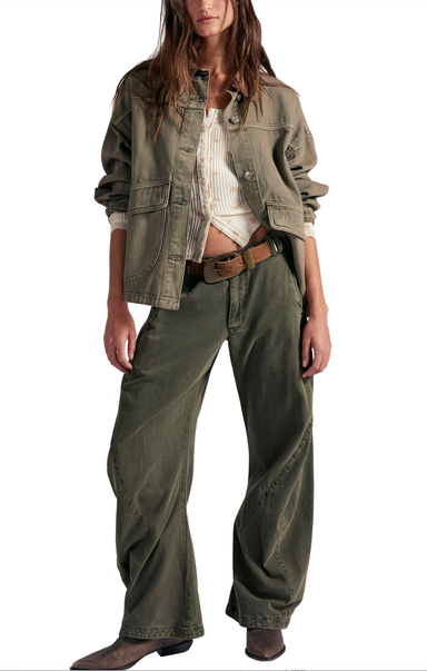 Person wearing a green jacket and wide-leg pants on a white background