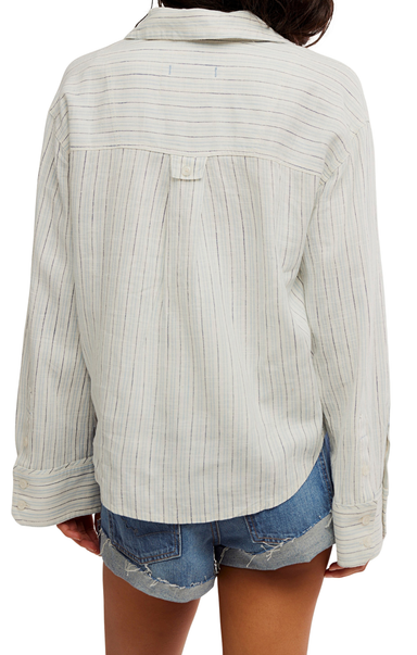 Light-colored ribbed sweater worn by a person on a white background
