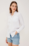Woman wearing a white shirt and denim shorts on a plain background