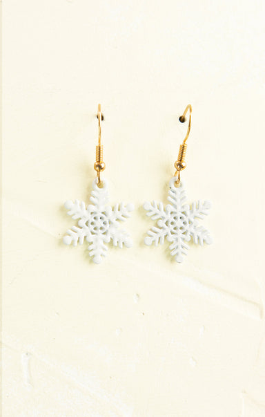 Snowflake earrings on a beige background