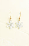 Snowflake earrings on a beige background