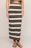 Person wearing a long black and beige striped skirt on a plain background