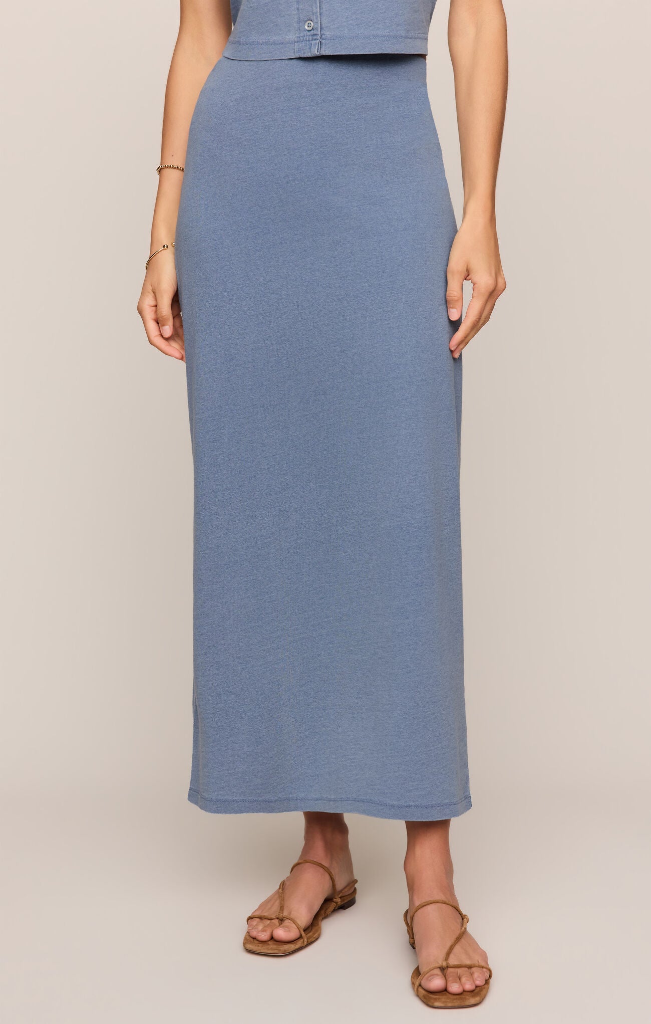 Person wearing a blue skirt on a beige background
