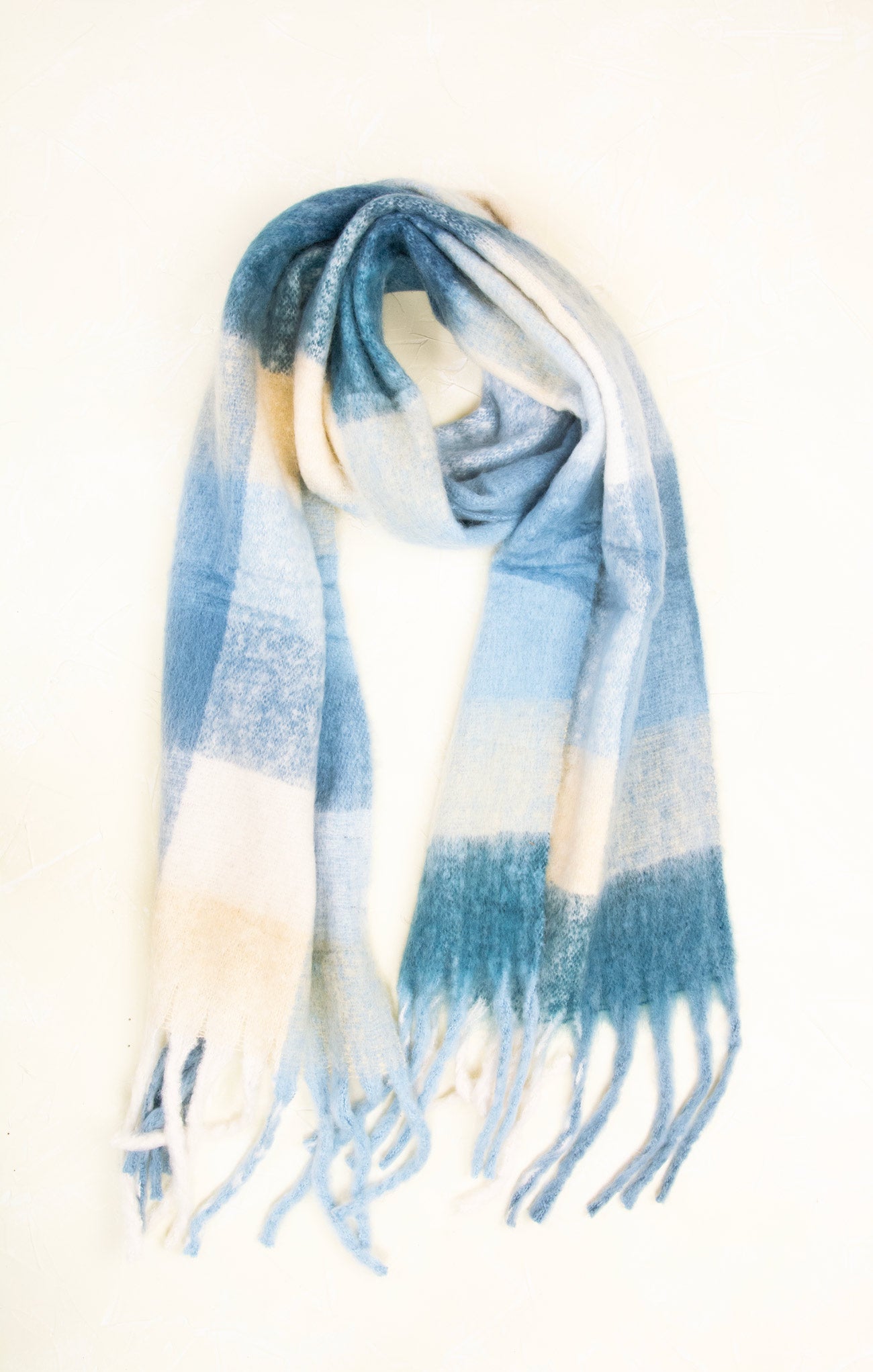 Blue and white plaid scarf with tassels on a mannequin against a white background