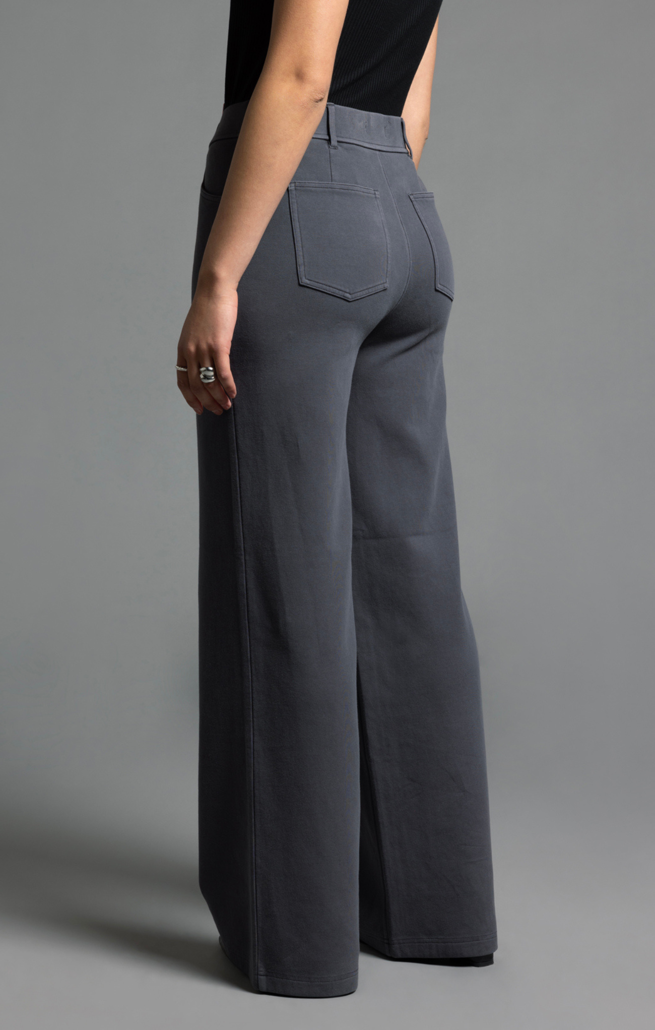 Person wearing gray wide-leg pants on a gray background