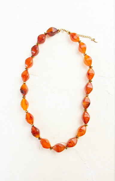 Necklace with orange and red beads on a white background