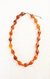 Necklace with orange and red beads on a white background