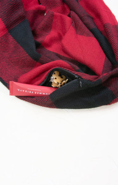 Red and black plaid fabric with a visible brand tag on a white background