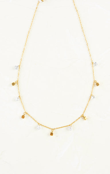 Gold necklace with small pendants on a white background