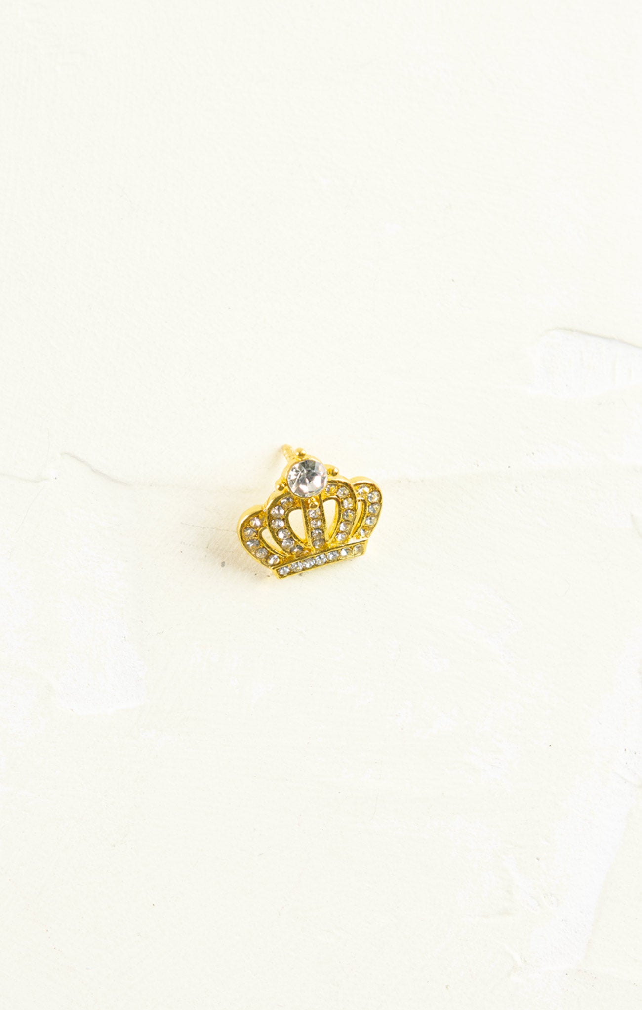 Gold crown-shaped earring on a white background