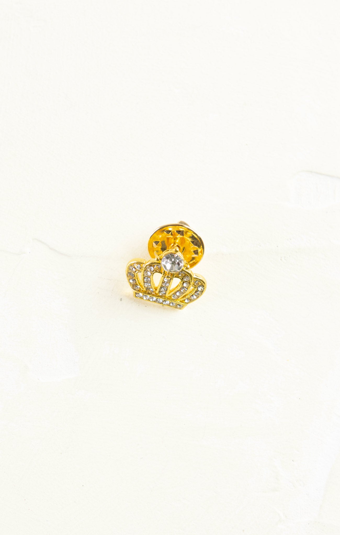 Gold crown-shaped earring with a yellow gemstone on a white background