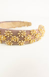 Beige headband with gold bead embellishments on a white background