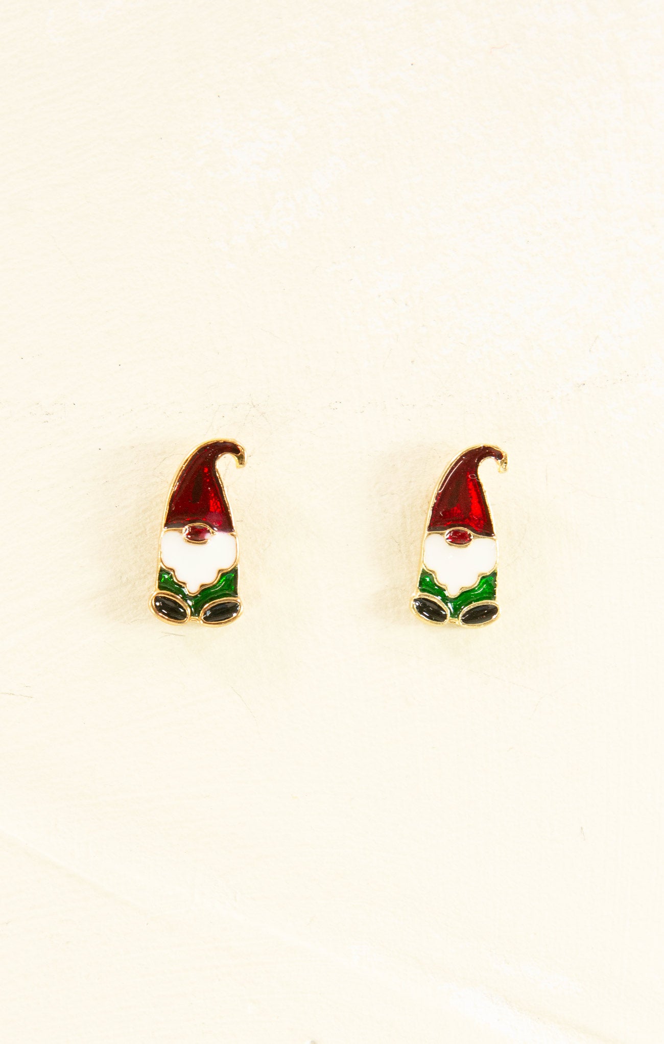 Gnome-shaped earrings on a beige background