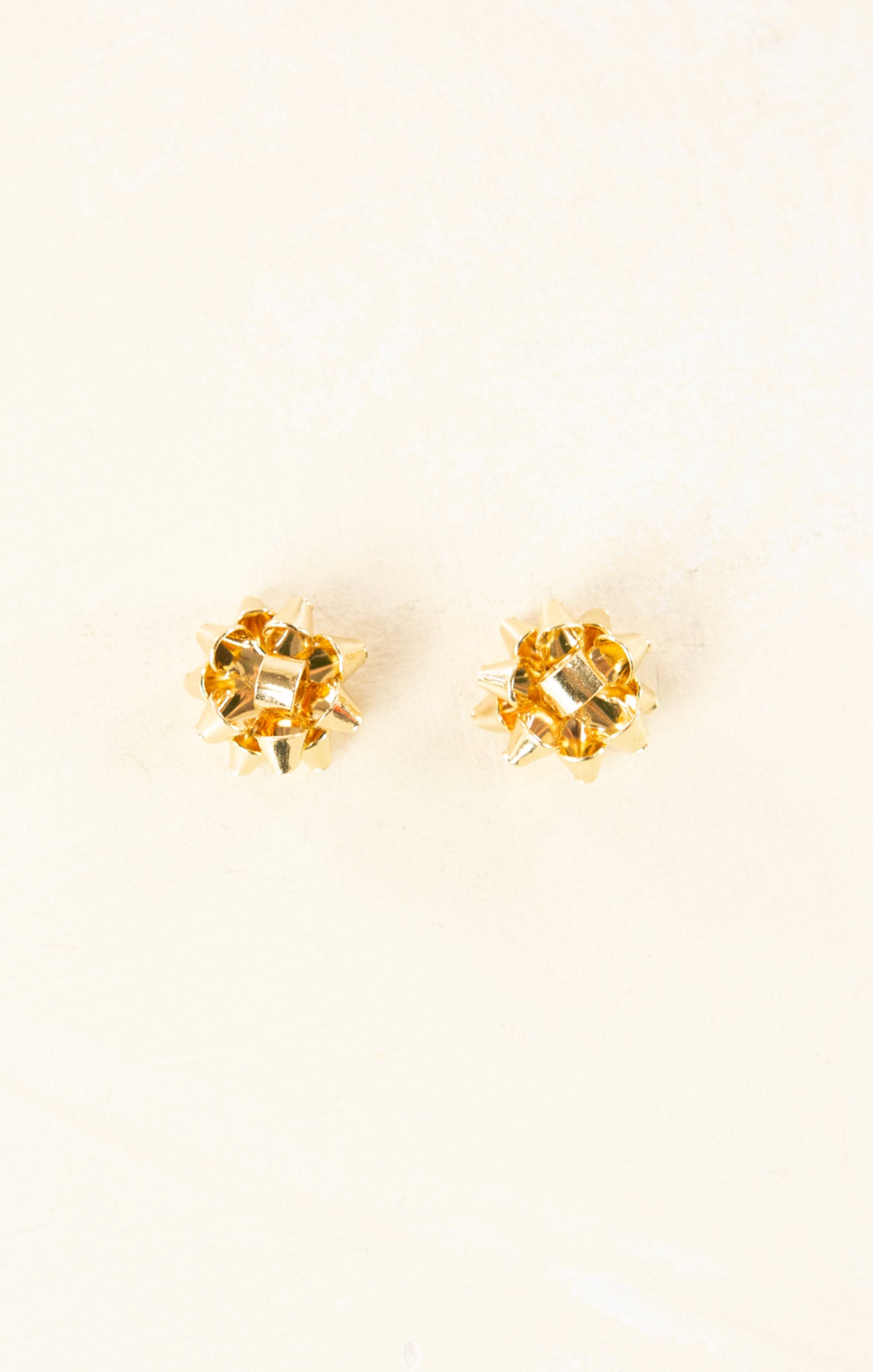 Gold stud earrings with clear gemstones on a white background