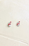 Pair of earrings with red and white designs on a beige background