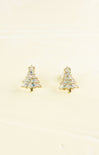 Gold tree-shaped earrings with clear gemstones on a beige background