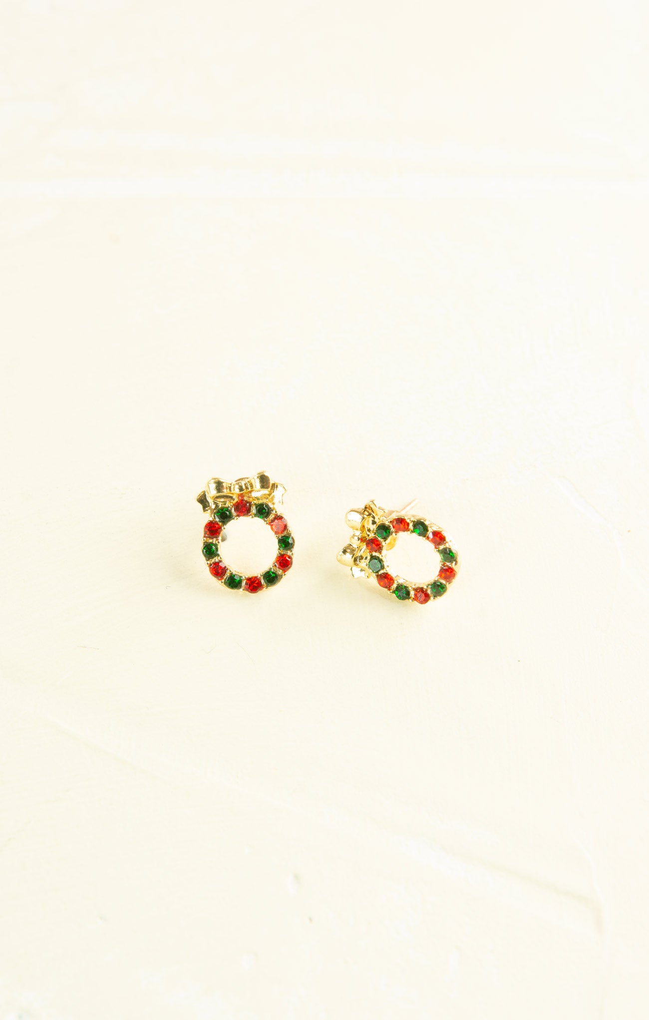 Gold hoop earrings with red and green accents on a white background